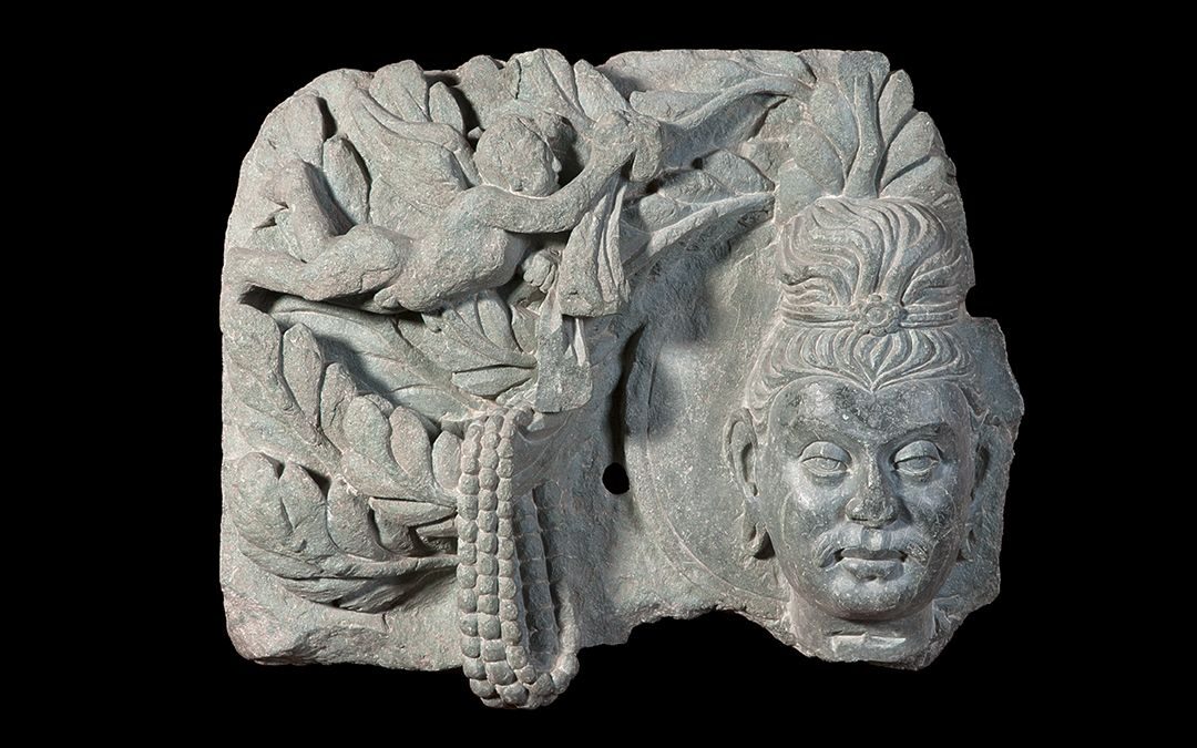 Frammento di rilievo con testa di Buddha sotto a un albero